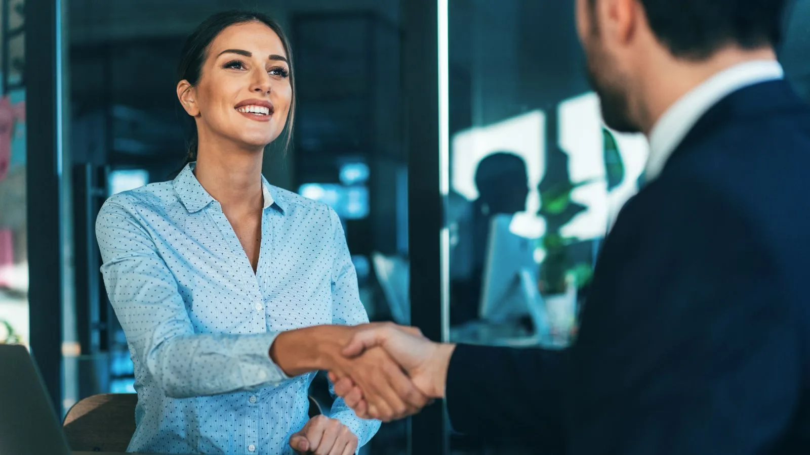 Two people shaking hands over a table