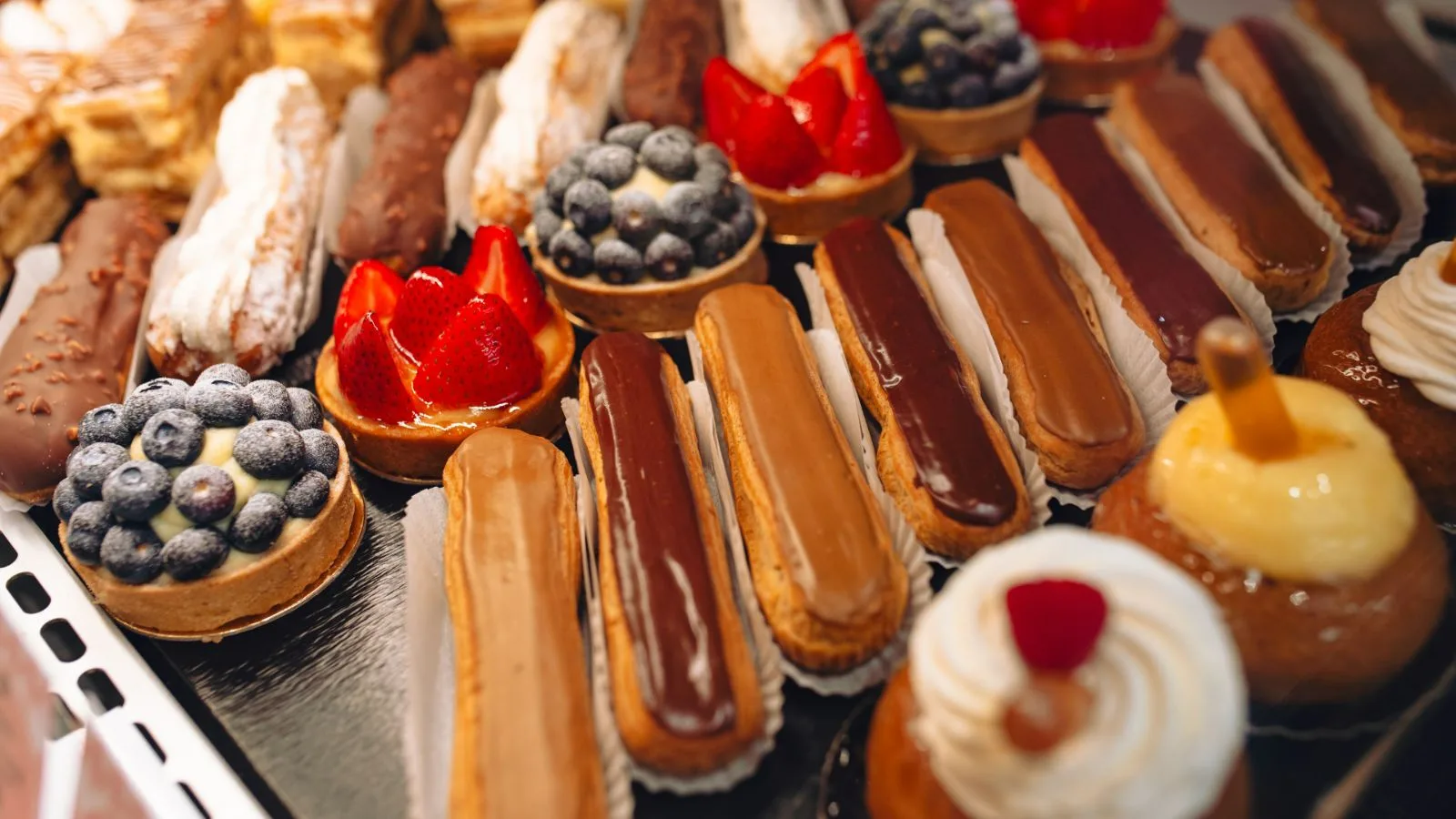 Patisserie display of éclairs, fruit tarts and cream pastries